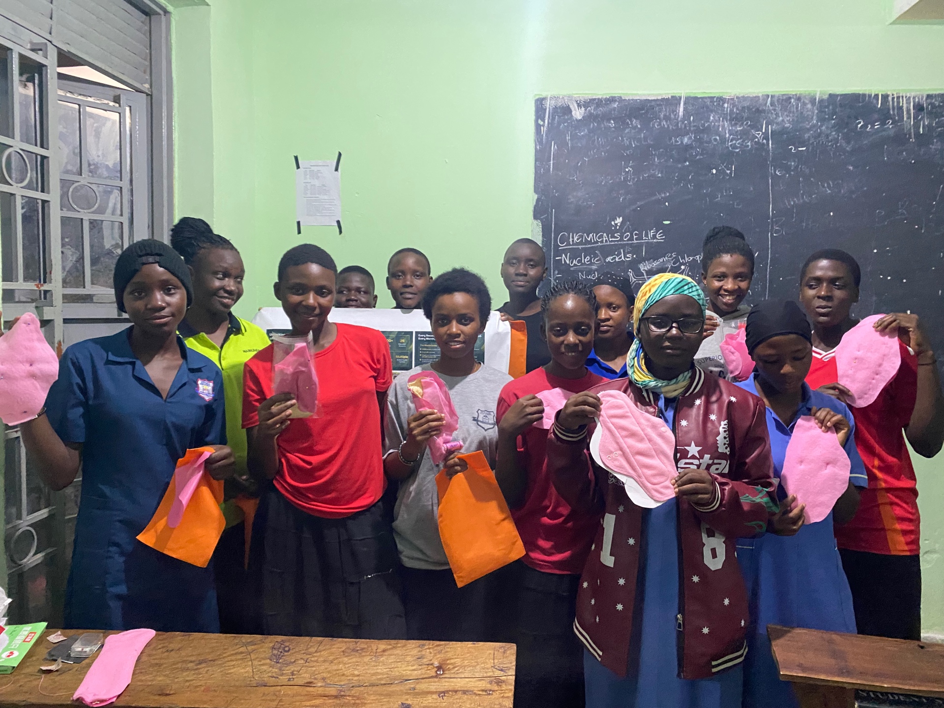 Group of girls proudly holding their finished reusable pads
